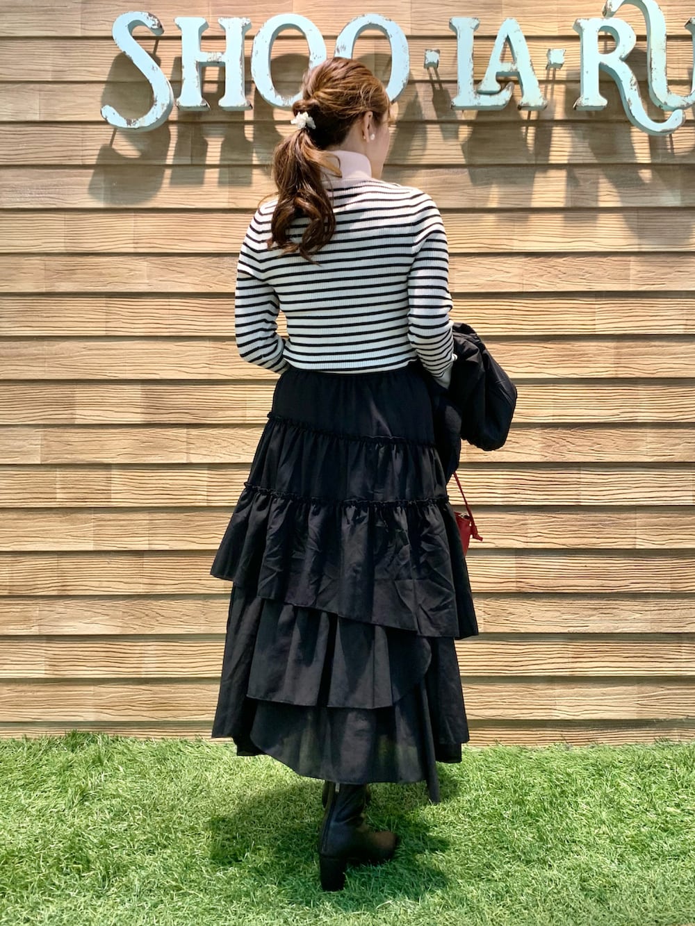 ブラック系のブルゾン、ホワイト系のニット/セーター、ブラック系のスカートを着用したレディースの秋コーディネートの5枚目の写真