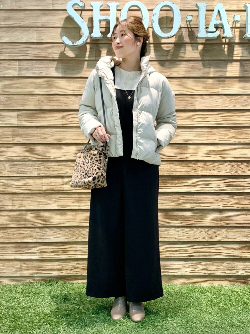 ベージュ系のダウンジャケット/コート、ベージュ系のニット/セーター、ブラック系のサロペット/オーバーオールを着用したレディースの冬コーディネートの2枚目の写真