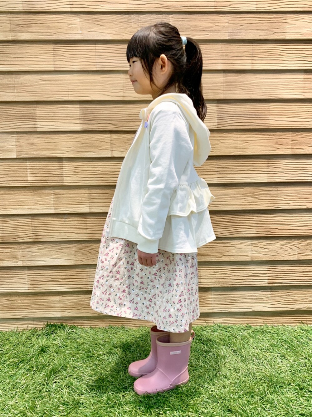 ホワイト系のパーカー、ピンク系のワンピース、ピンク系のショルダーバッグを着用したキッズの春コーディネートの3枚目の写真