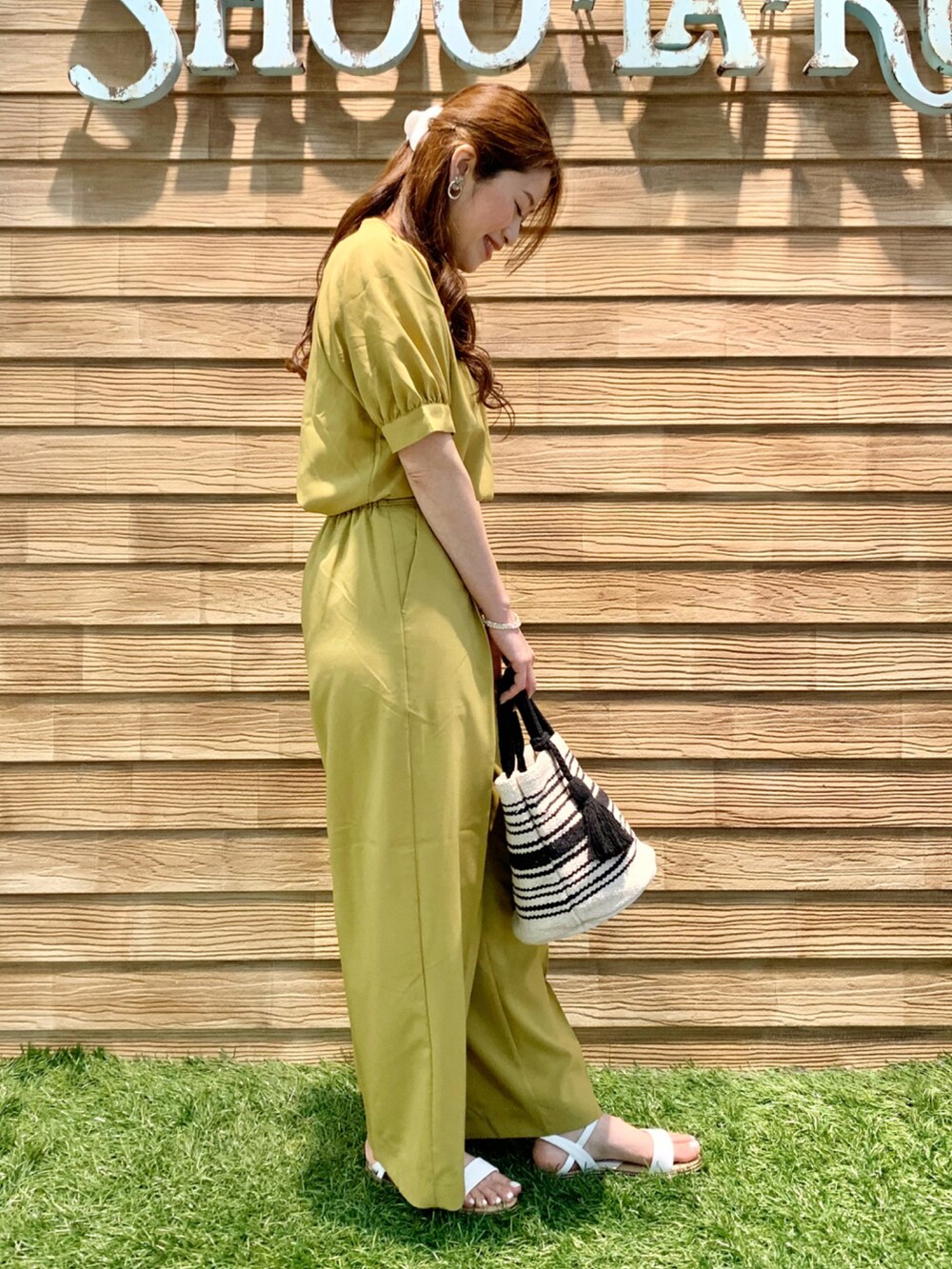 イエロー系のシャツ/ブラウス、イエロー系のその他パンツ、ブラック系のトートバッグを着用したレディースの夏コーディネートの4枚目の写真