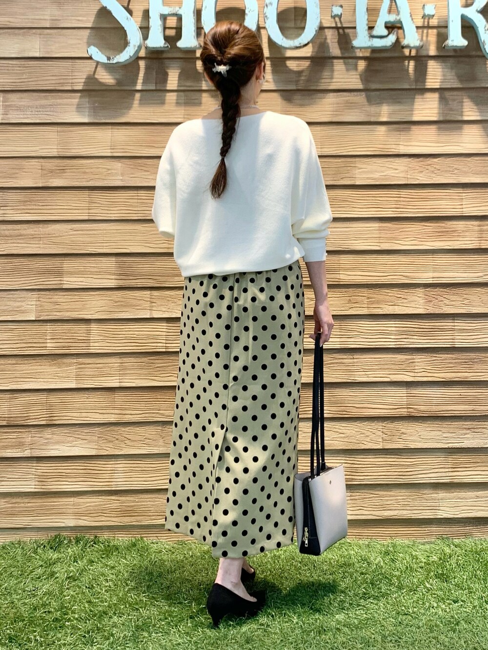 ホワイト系のニット/セーター、グリーン系のスカート、ブラック系のショルダーバッグを着用したレディースの春コーディネートの5枚目の写真