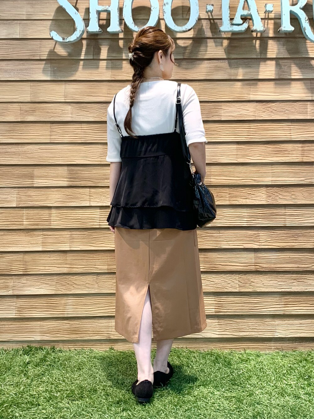 ブラック系のタンクトップ、ホワイト系のTシャツ/カットソー、イエロー系のスカートを着用したレディースの秋コーディネートの5枚目の写真