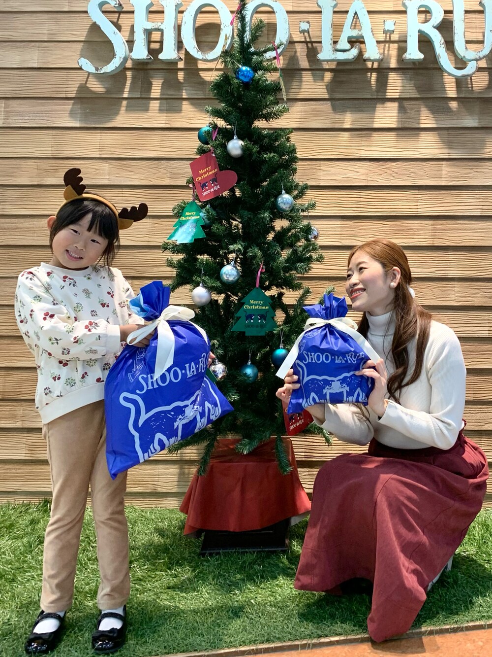 ホワイト系のニット/セーター、レッド系のスカート、ホワイト系のブーツを着用したレディースの冬コーディネートの5枚目の写真