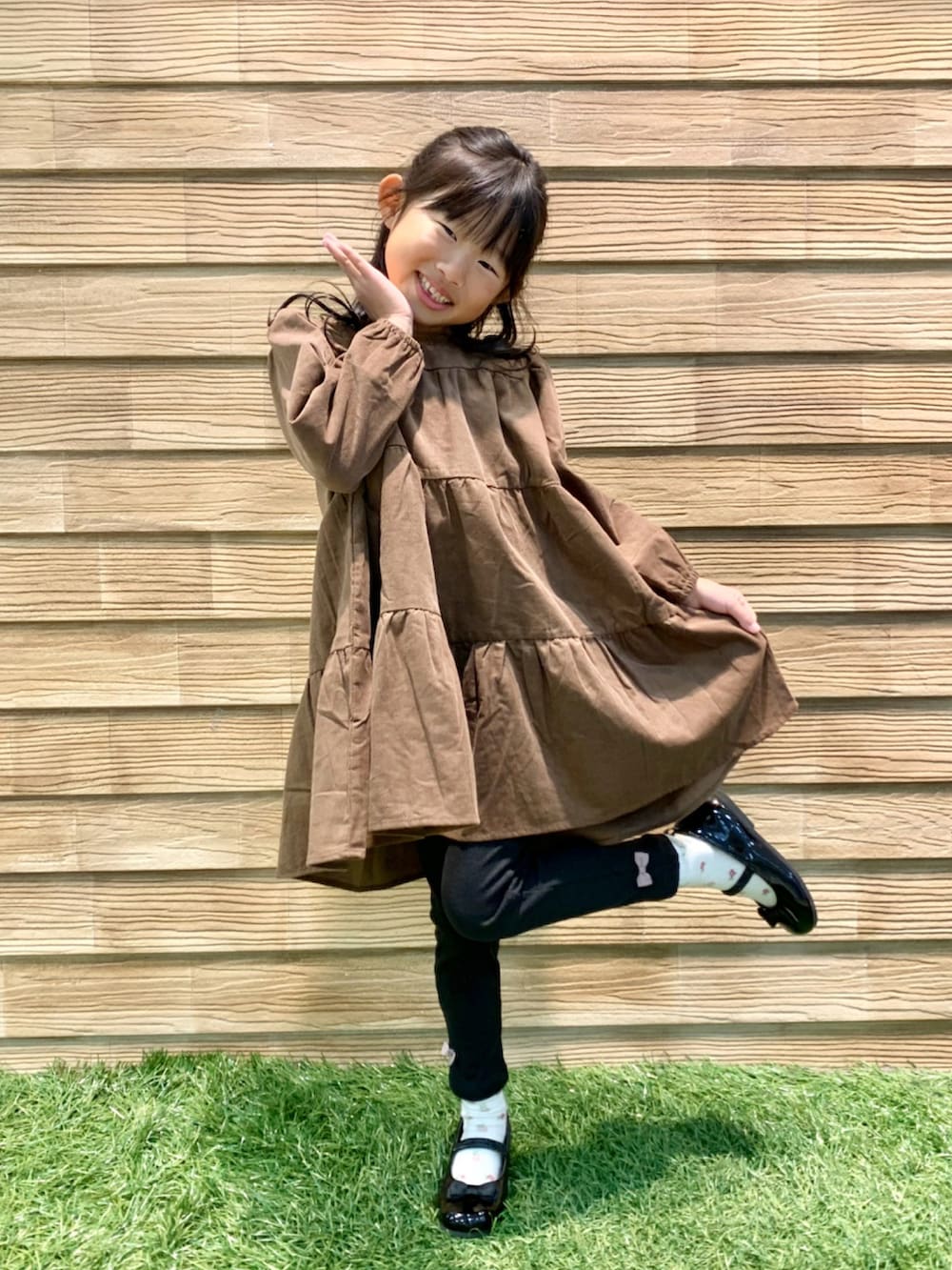 ブラウン系のワンピース、ブラック系のその他パンツ、ブラック系のドレスシューズを着用したキッズの冬コーディネートの2枚目の写真