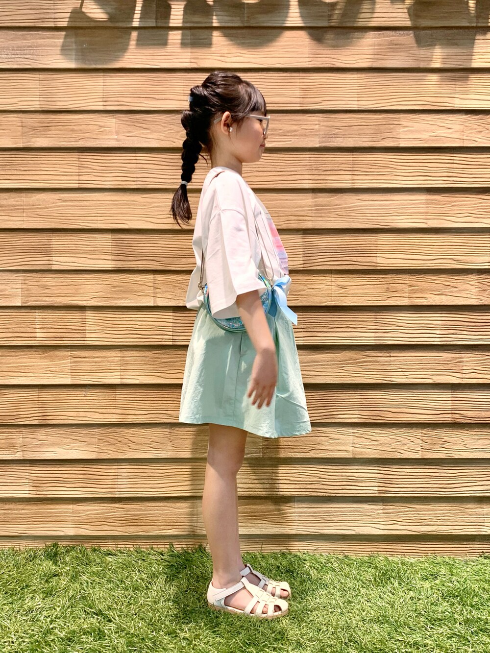 ホワイト系のTシャツ/カットソー、グリーン系のスカート、ブルー系のショルダーバッグを着用したキッズの秋コーディネートの4枚目の写真