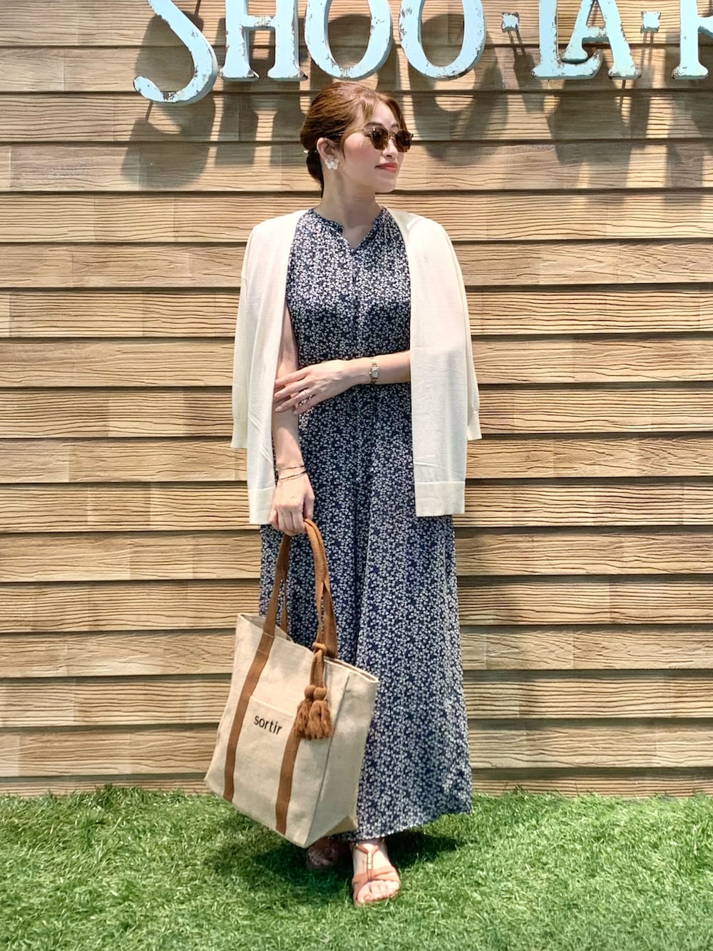 ブルー系のサロペット/オーバーオール、ブラック系のタンクトップ、ベージュ系のカーディガン/ボレロを着用したレディースの秋コーディネートの2枚目の写真