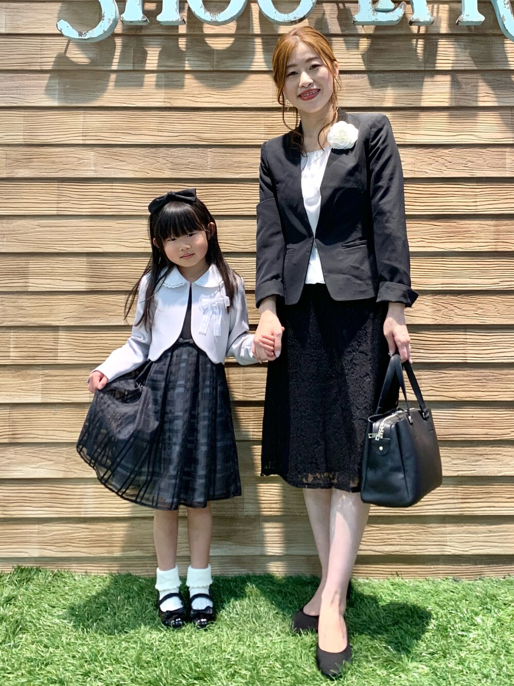 ブラック系のノーカラージャケット、ホワイト系のシャツ/ブラウス、ブラック系のスカートを着用したレディースの冬コーディネートの2枚目の写真