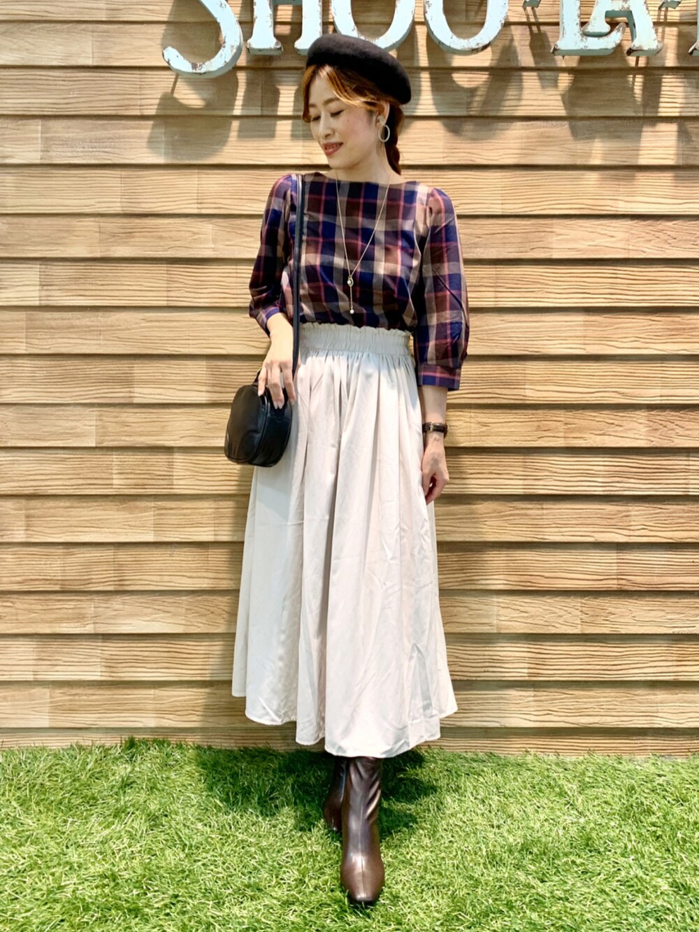 ブラウン系のシャツ/ブラウス、ホワイト系のスカート、ブラック系のショルダーバッグを着用したレディースの秋コーディネートの2枚目の写真