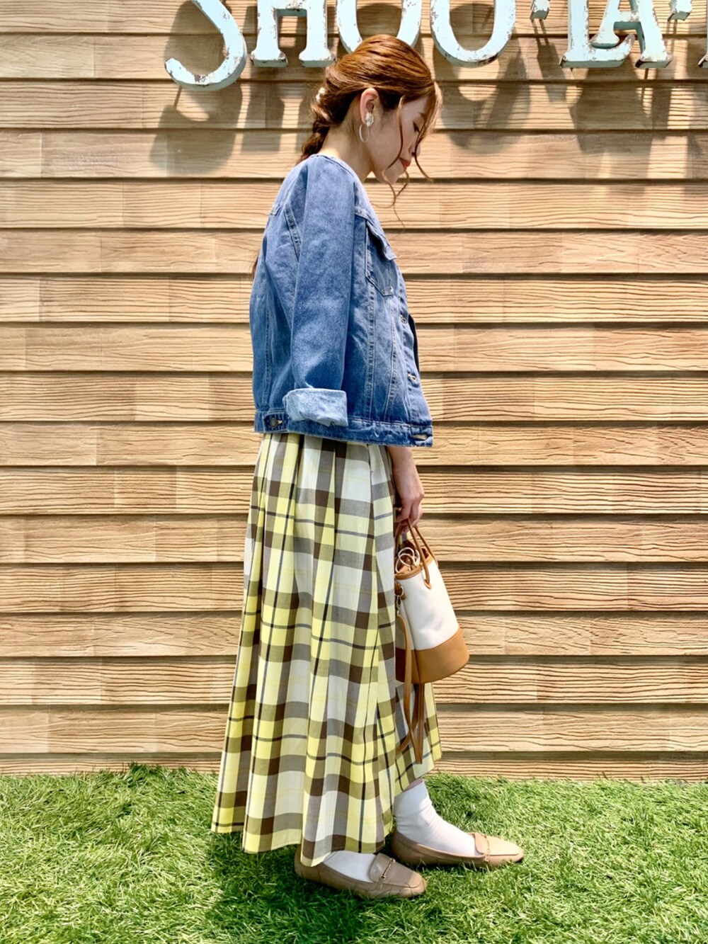 ブルー系のデニムジャケット、ホワイト系のニット/セーター、イエロー系のスカートを着用したレディースの春コーディネートの3枚目の写真