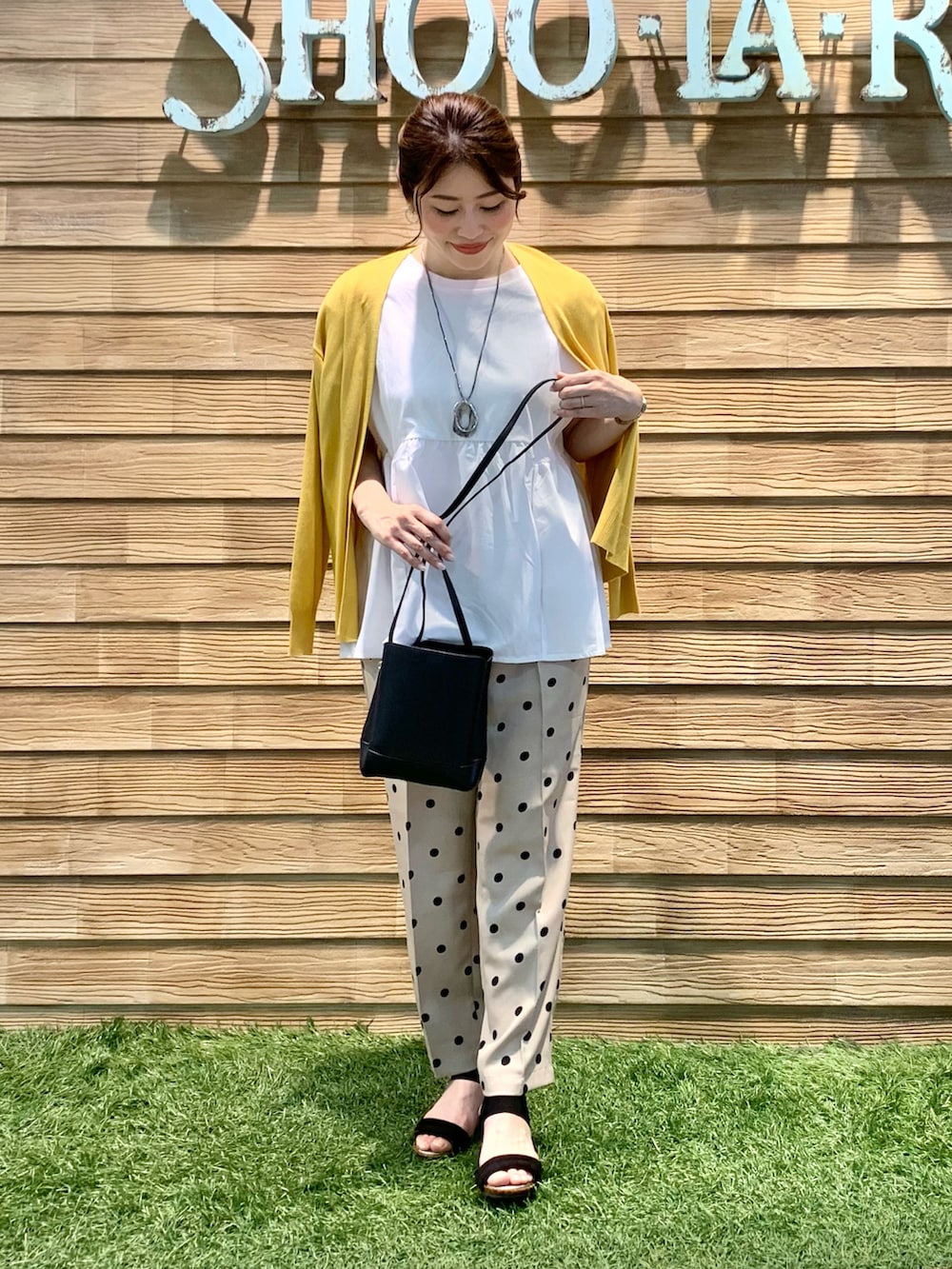 イエロー系のカーディガン/ボレロ、ホワイト系のTシャツ/カットソー、ベージュ系のその他パンツを着用したレディースの秋コーディネートの3枚目の写真