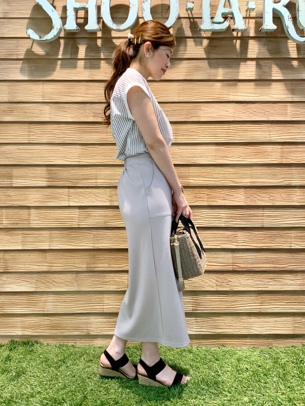ホワイト系のシャツ/ブラウス、グレー系のスカート、グレー系のショルダーバッグを着用したレディースの夏コーディネートの4枚目の写真