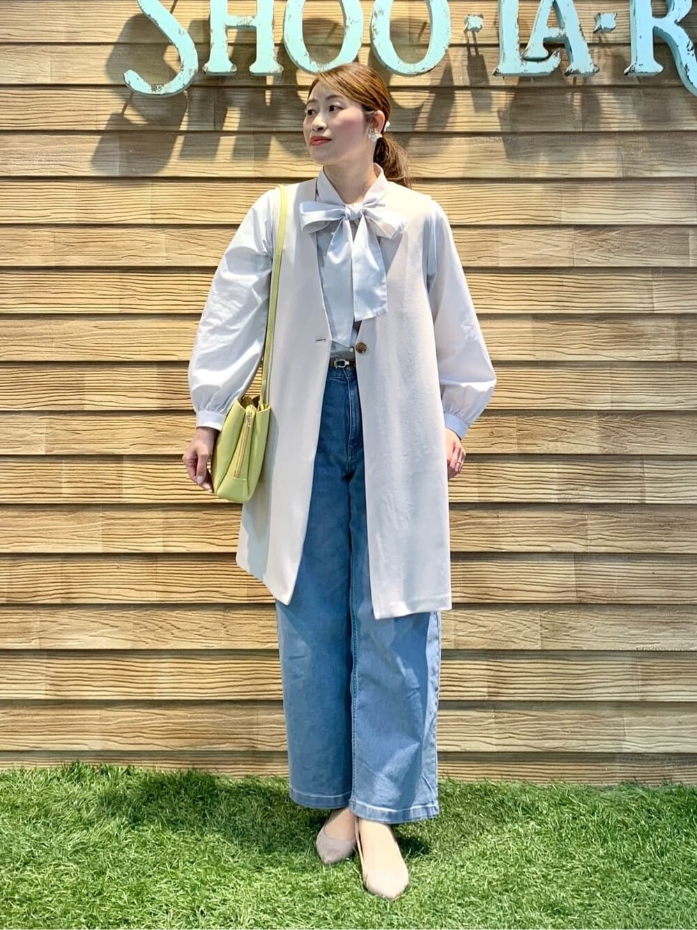 グレー系のシャツ/ブラウス、ベージュ系のベスト、イエロー系のショルダーバッグを着用したレディースの春コーディネートの4枚目の写真