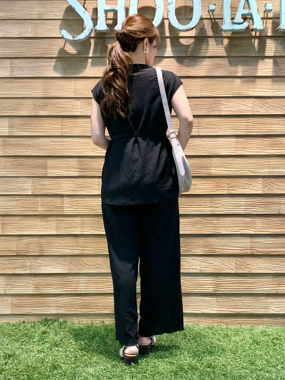 ブラック系のTシャツ/カットソー、ブラック系のその他パンツ、グレー系のショルダーバッグを着用したレディースの秋コーディネートの5枚目の写真