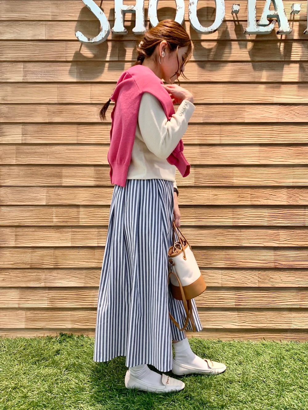 ピンク系のニット/セーター、ホワイト系のニット/セーター、ブルー系のスカートを着用したレディースの春コーディネートの4枚目の写真