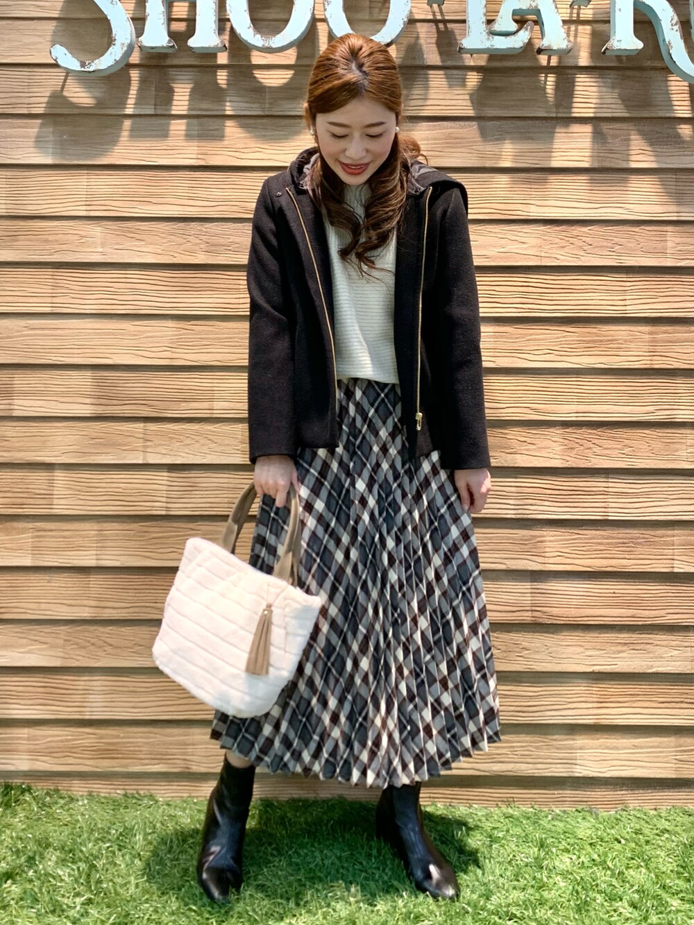 ブラック系のその他アウター、ホワイト系のニット/セーター、レッド系のスカートを着用したレディースの冬コーディネートの2枚目の写真