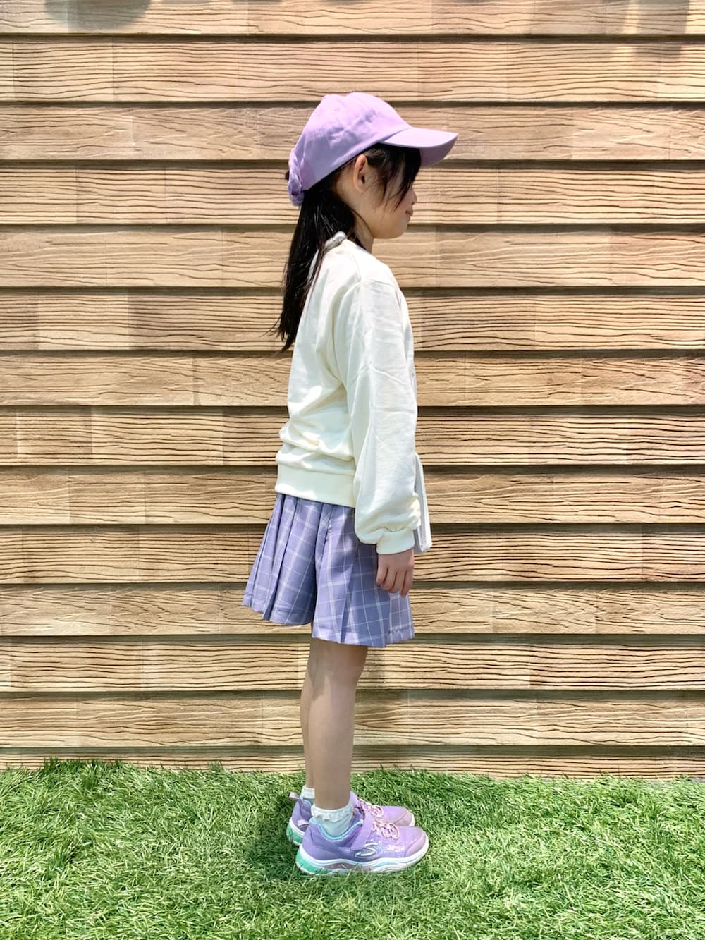 ホワイト系のスウェット、パープル系のスカート、ホワイト系のショルダーバッグを着用したキッズの春コーディネートの3枚目の写真