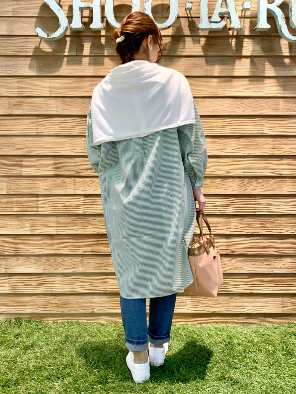 グリーン系のワンピース、ホワイト系のカーディガン/ボレロ、ブルー系のデニムパンツを着用したレディースの春コーディネートの5枚目の写真