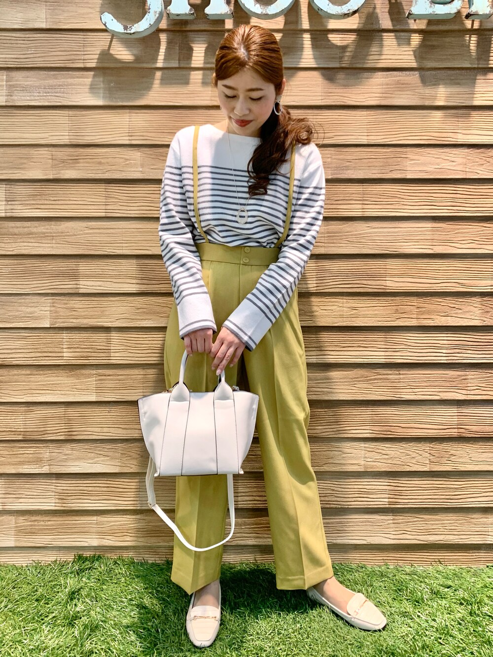 グレー系のニット/セーター、イエロー系のその他パンツ、ホワイト系のトートバッグを着用したレディースの冬コーディネートの3枚目の写真