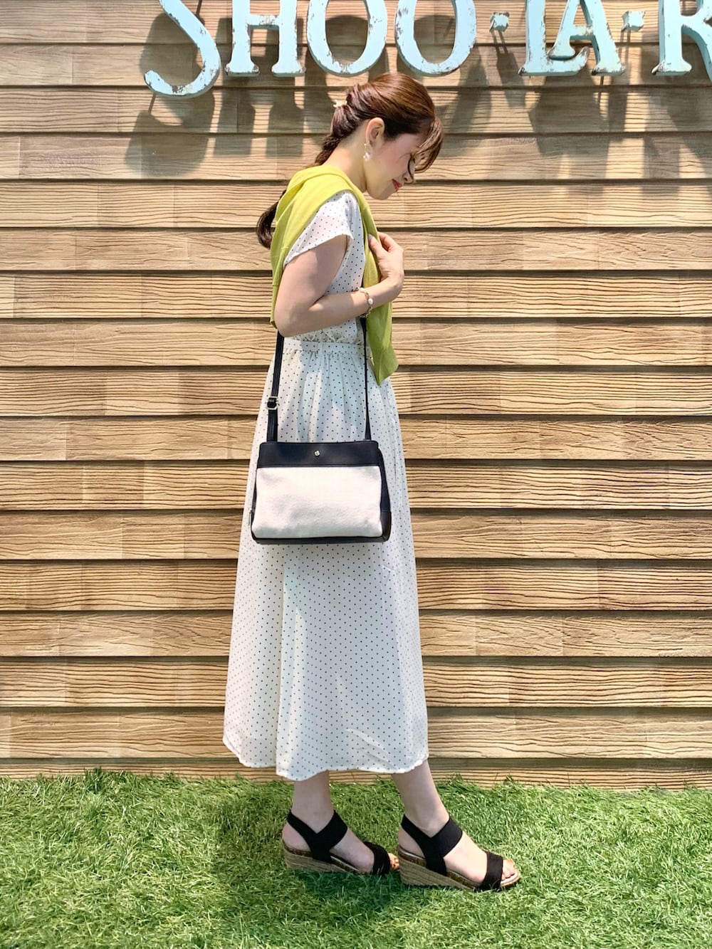 ベージュ系のワンピース、イエロー系のカーディガン/ボレロ、ブラック系のショルダーバッグを着用したレディースの夏コーディネートの4枚目の写真