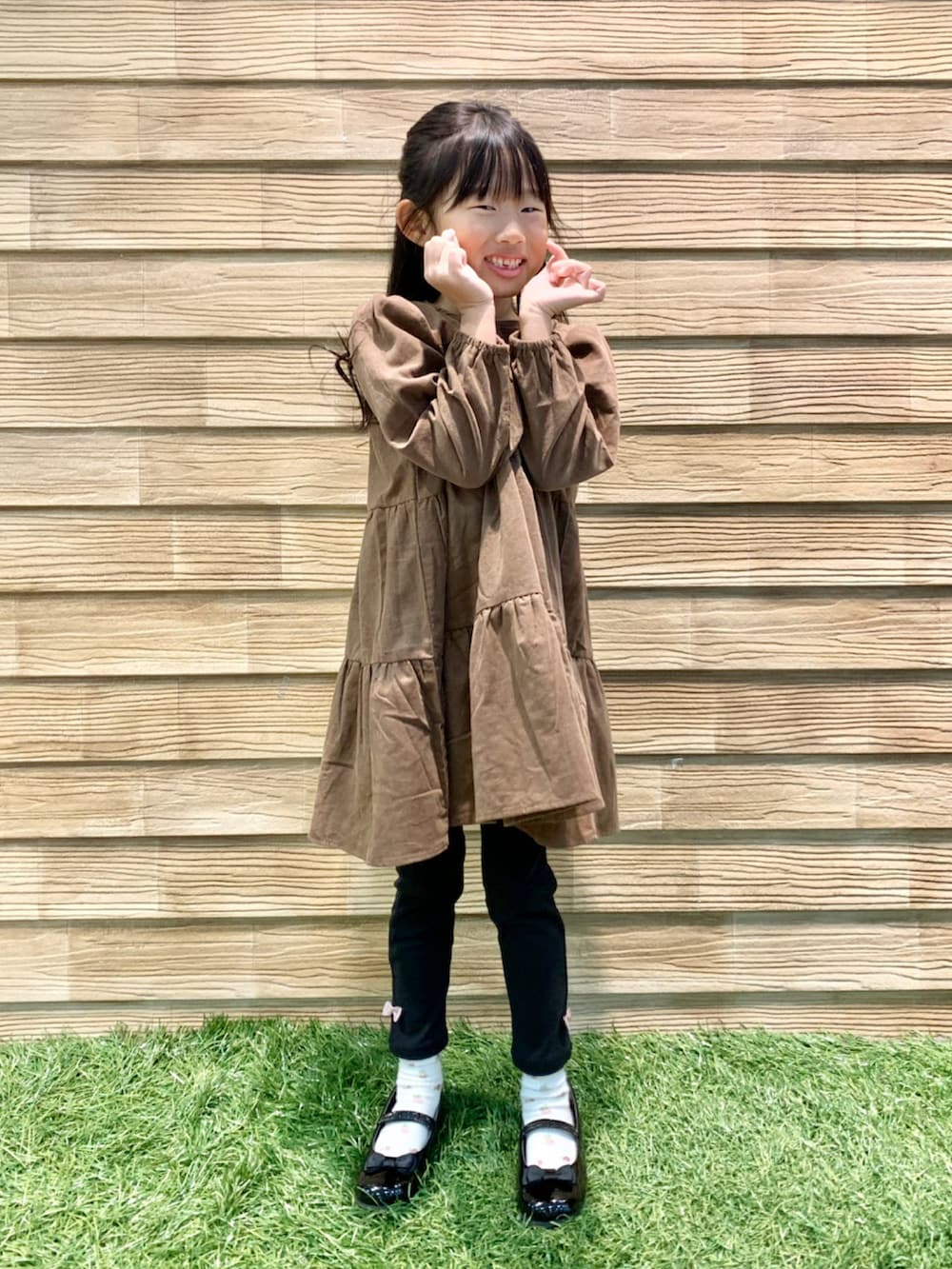 ブラウン系のワンピース、ブラック系のその他パンツ、ブラック系のドレスシューズを着用したキッズの冬コーディネートの3枚目の写真