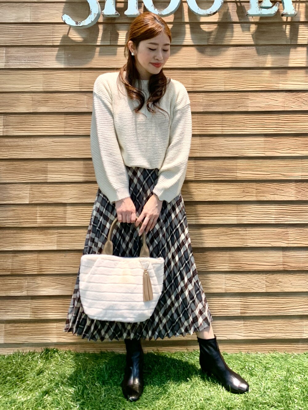 ブラック系のその他アウター、ホワイト系のニット/セーター、レッド系のスカートを着用したレディースの冬コーディネートの5枚目の写真