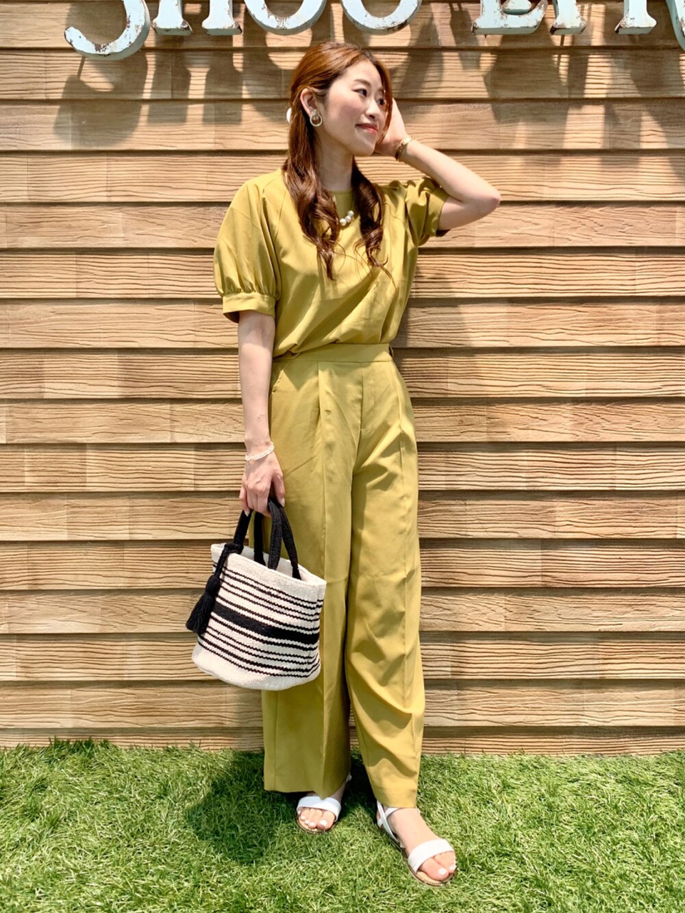 イエロー系のシャツ/ブラウス、イエロー系のその他パンツ、ブラック系のトートバッグを着用したレディースの夏コーディネートの2枚目の写真