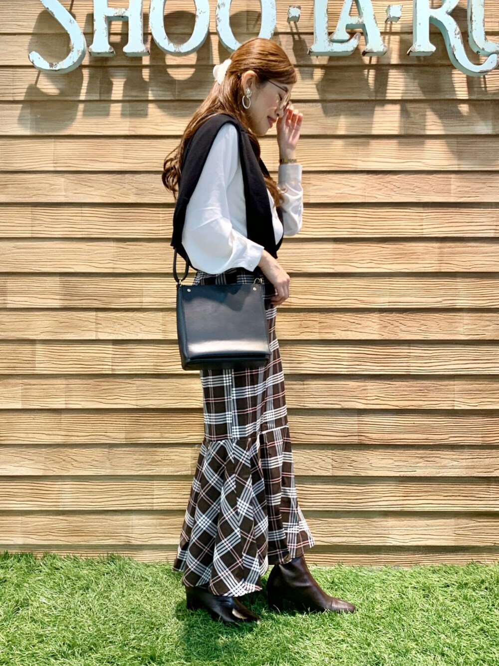 ブラック系のカーディガン/ボレロ、ホワイト系のシャツ/ブラウス、ブラウン系のスカートを着用したレディースの秋コーディネートの4枚目の写真