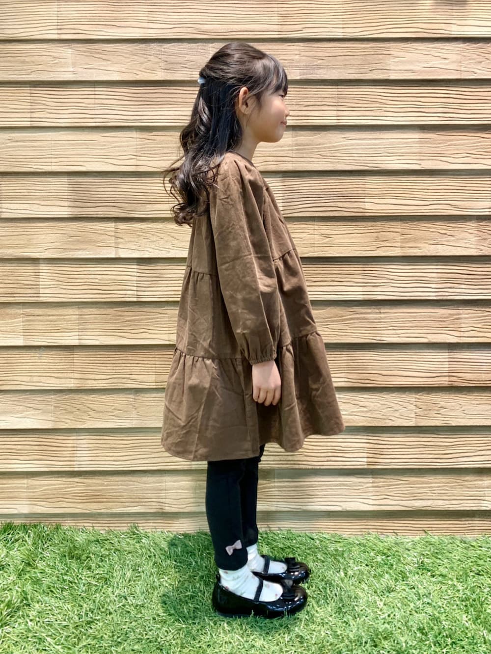 ブラウン系のワンピース、ブラック系のその他パンツ、ブラック系のドレスシューズを着用したキッズの冬コーディネートの4枚目の写真