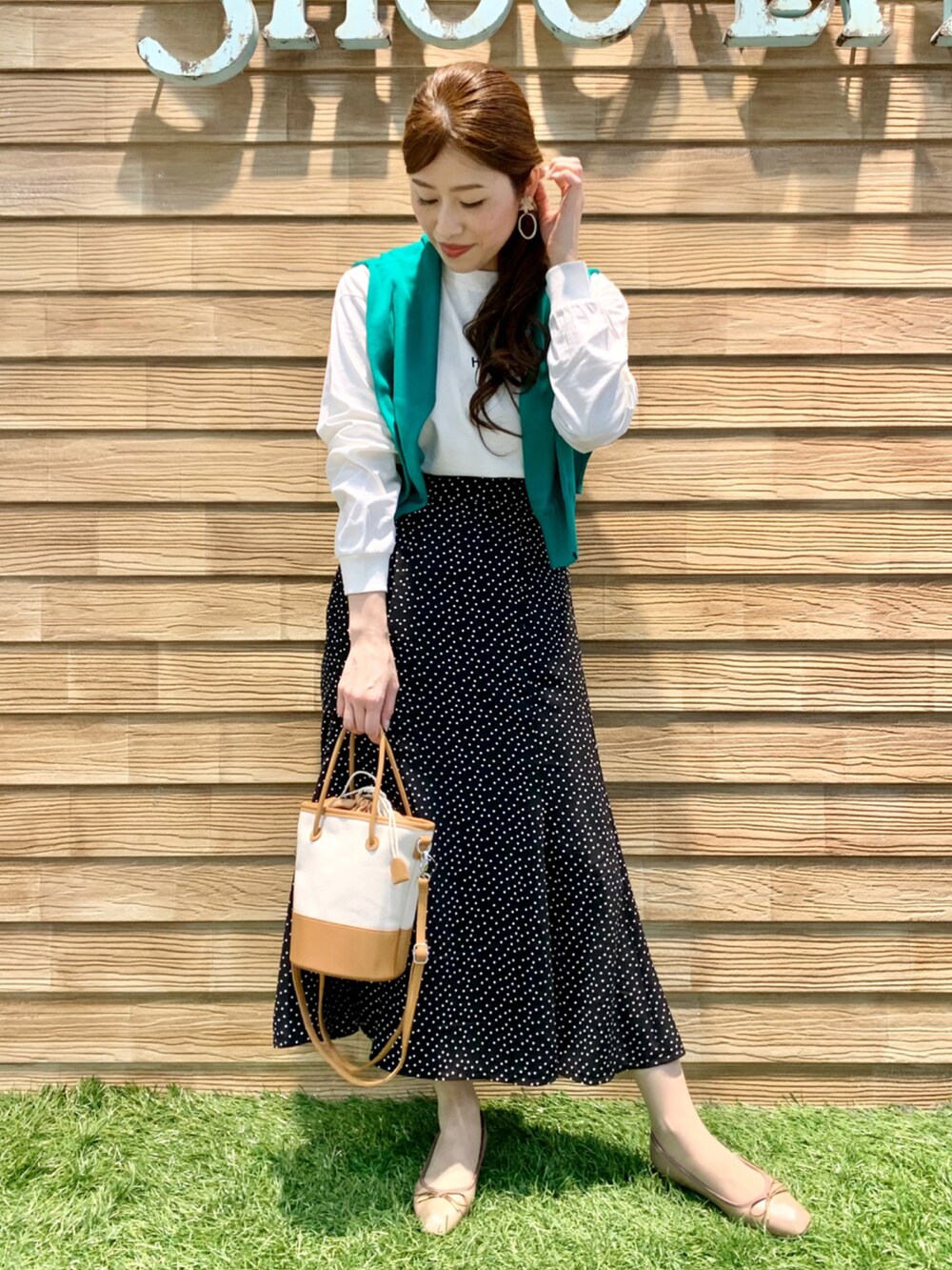 ホワイト系のTシャツ/カットソー、グリーン系のカーディガン/ボレロ、ブラック系のスカートを着用したレディースの春コーディネートの3枚目の写真