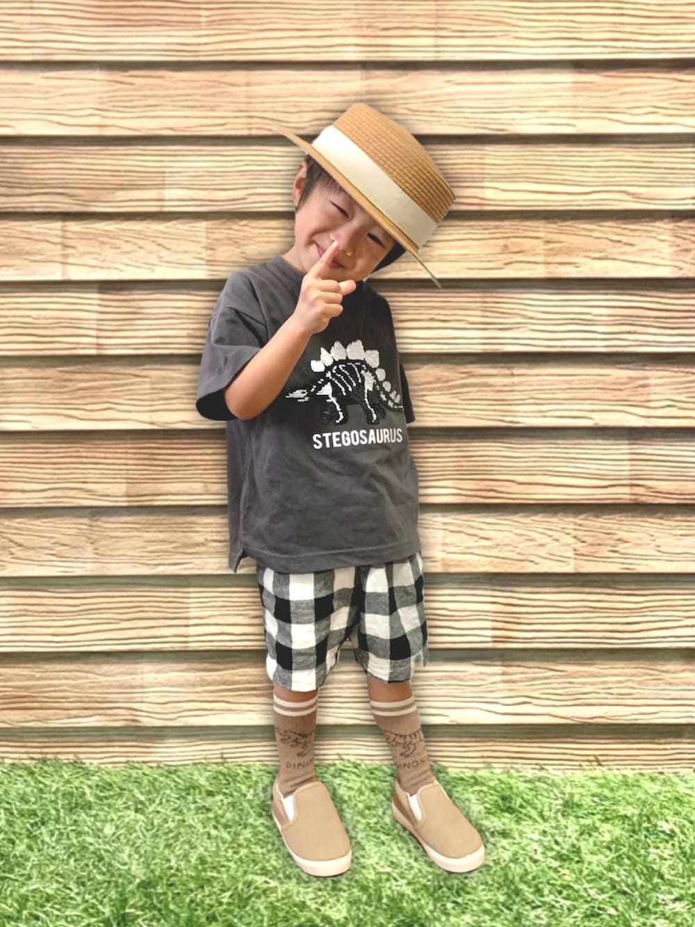 ベージュ系のハット、グリーン系のラッピングキット、グレー系のラッピングキットを着用したキッズの秋コーディネートの2枚目の写真