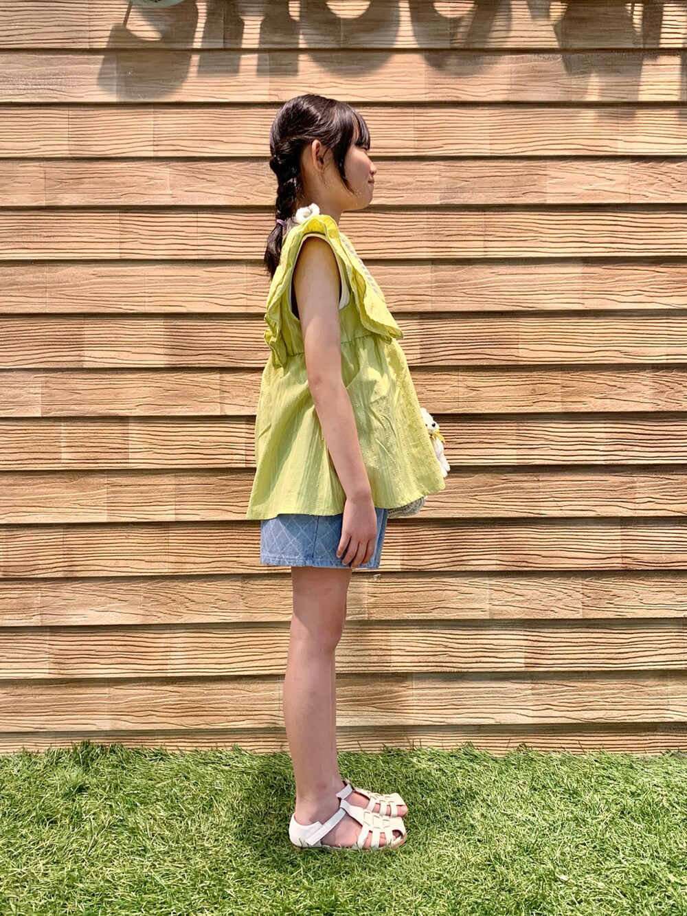 イエロー系のシャツ/ブラウス、ホワイト系のショルダーバッグ、ブルー系のデニムパンツを着用したキッズの夏コーディネートの4枚目の写真
