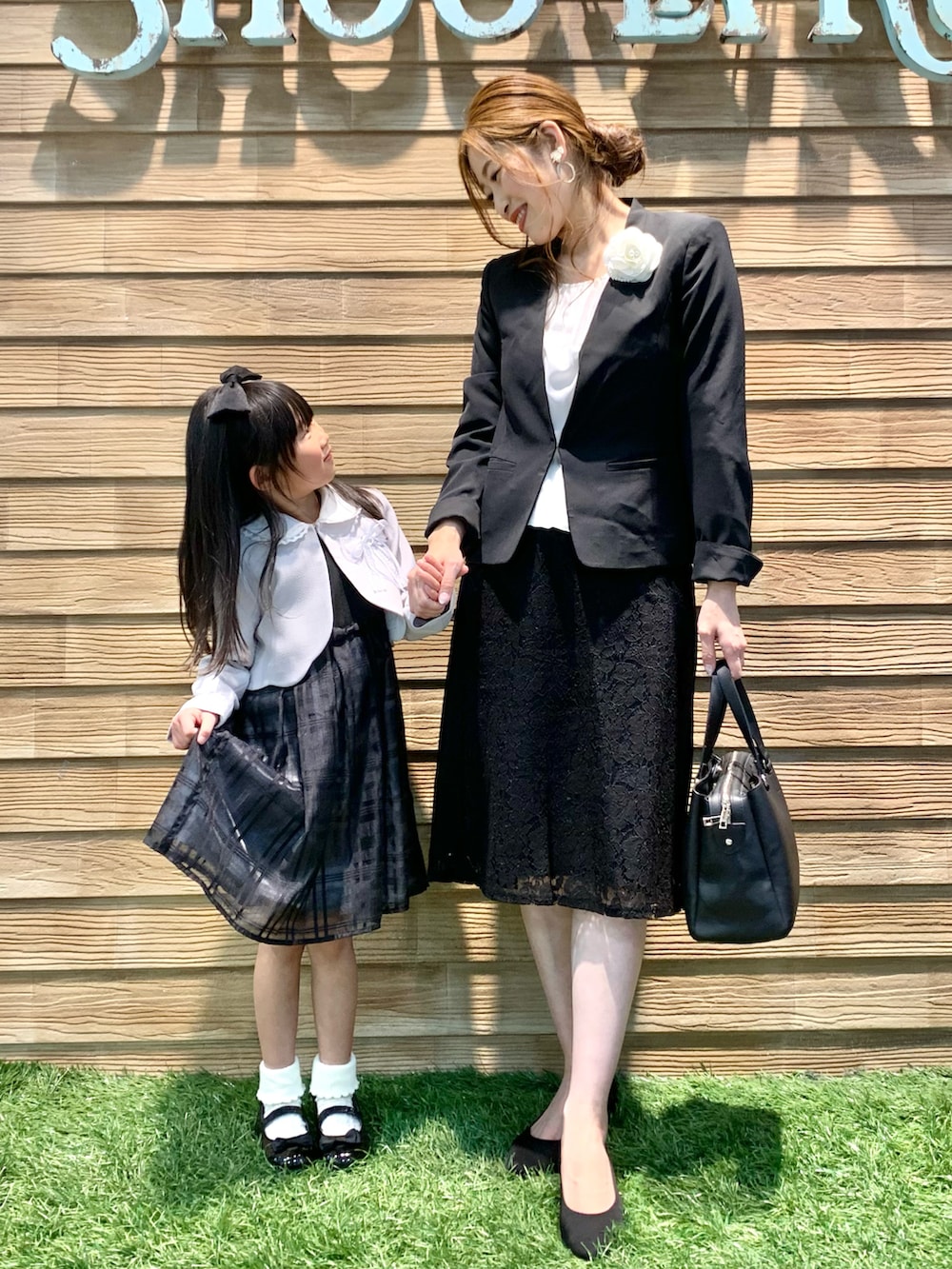 ブラック系のノーカラージャケット、ホワイト系のシャツ/ブラウス、ブラック系のスカートを着用したレディースの冬コーディネートの3枚目の写真