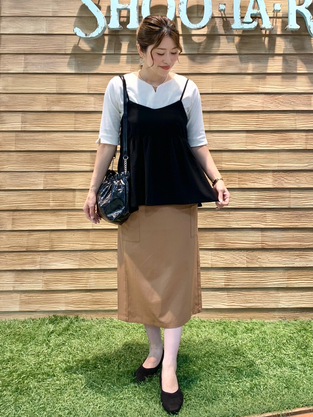 ブラック系のタンクトップ、ホワイト系のTシャツ/カットソー、イエロー系のスカートを着用したレディースの秋コーディネートの2枚目の写真