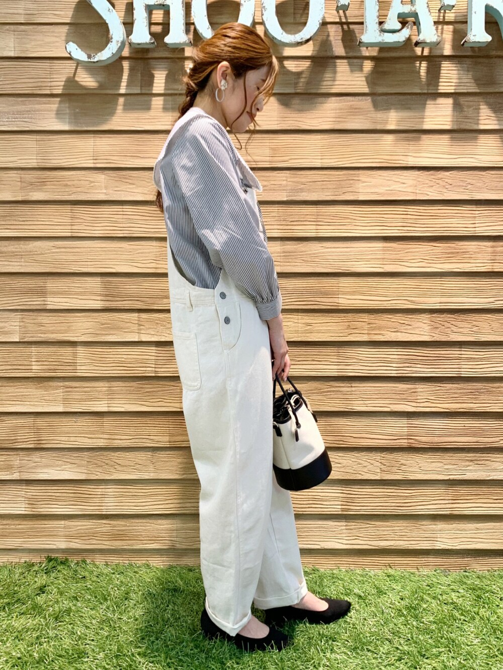 グレー系のシャツ/ブラウス、ホワイト系のサロペット/オーバーオール、ブラック系のハンドバッグを着用したレディースの冬コーディネートの4枚目の写真