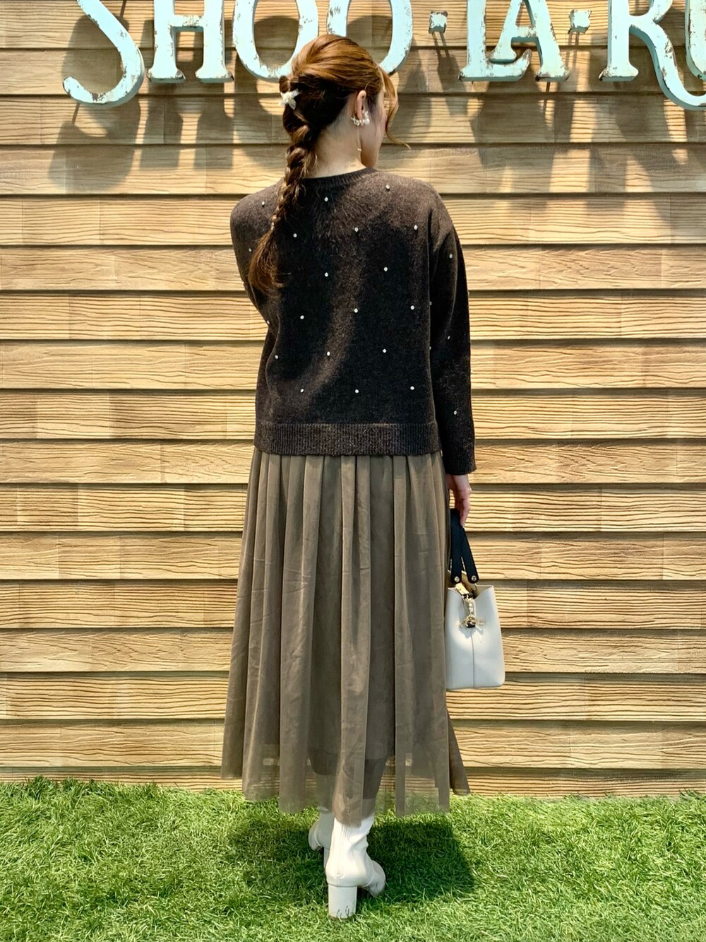 ブラウン系のニット/セーター、ブラウン系のスカート、ベージュ系のトートバッグを着用したレディースの冬コーディネートの5枚目の写真