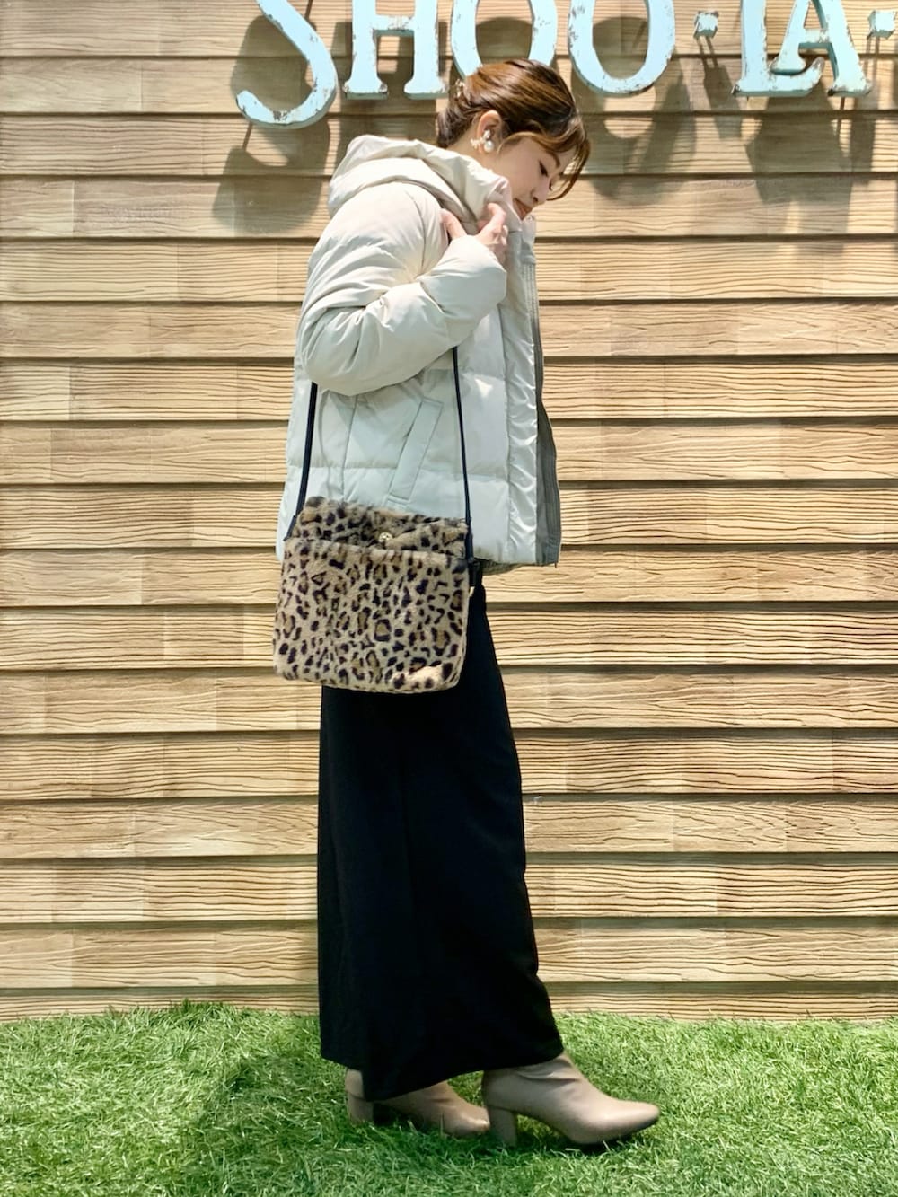 ベージュ系のダウンジャケット/コート、ベージュ系のニット/セーター、ブラック系のサロペット/オーバーオールを着用したレディースの冬コーディネートの3枚目の写真