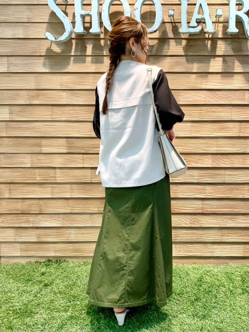 ベージュ系のベスト、ブラック系のTシャツ/カットソー、グリーン系のスカートを着用したレディースの夏コーディネートの5枚目の写真