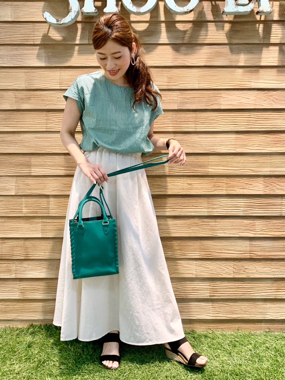 グリーン系のシャツ/ブラウス、ホワイト系のスカート、グリーン系のショルダーバッグを着用したレディースの夏コーディネートの2枚目の写真
