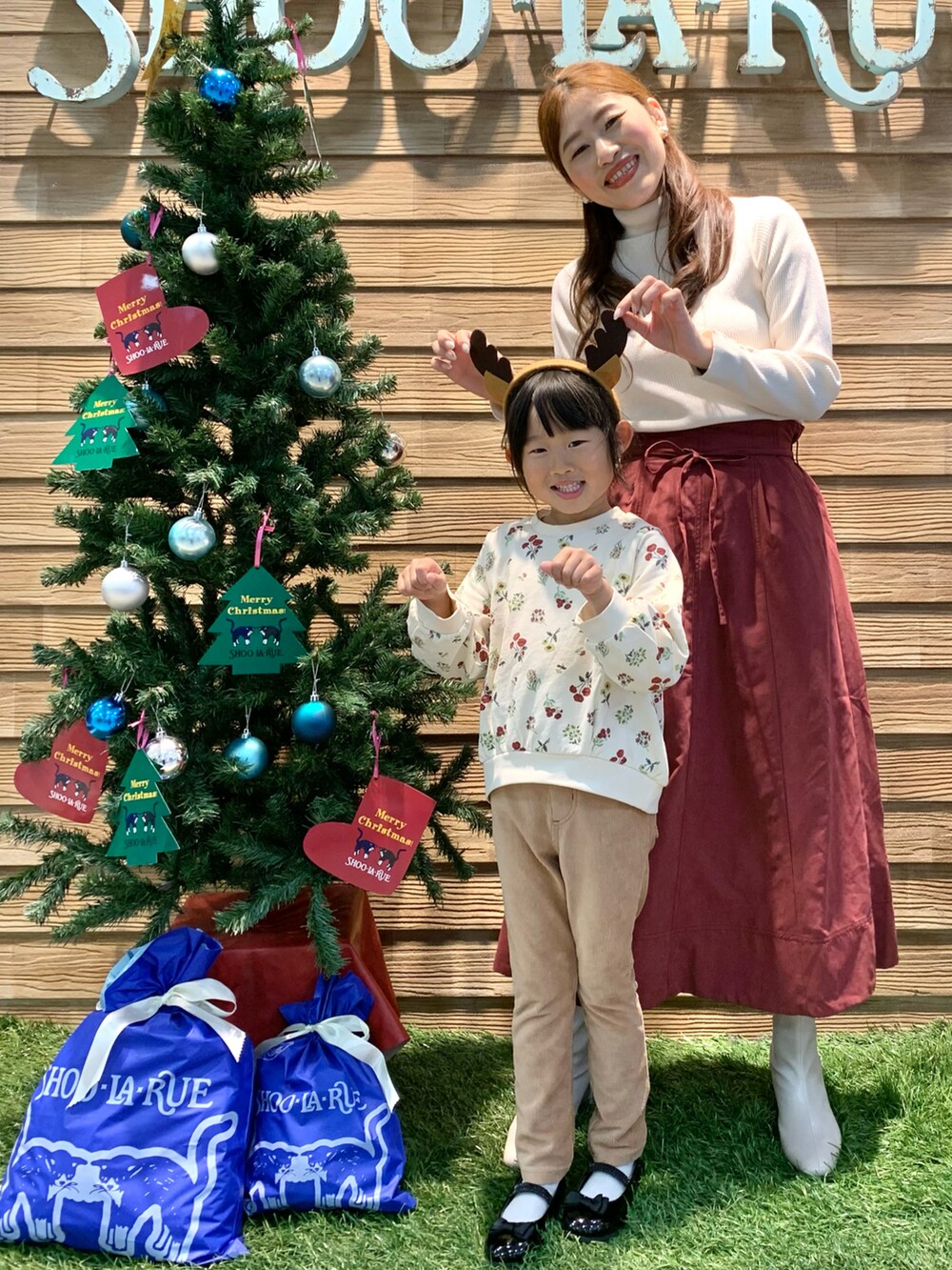 ホワイト系のニット/セーター、レッド系のスカート、ホワイト系のブーツを着用したレディースの冬コーディネートの3枚目の写真