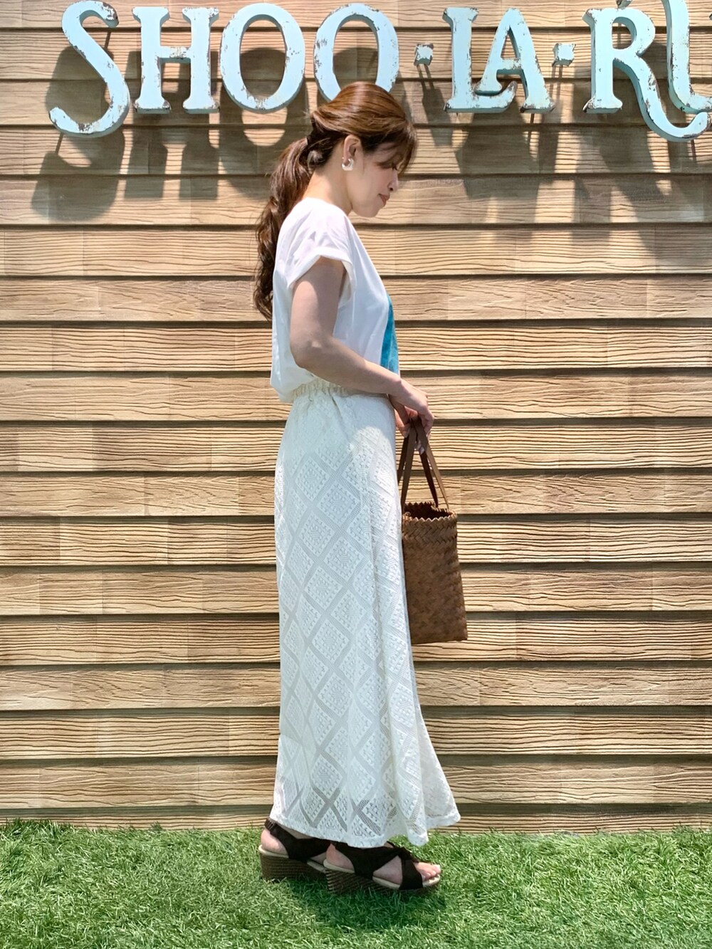 ホワイト系のTシャツ/カットソー、ホワイト系のスカート、ブラウン系のトートバッグを着用したレディースの夏コーディネートの4枚目の写真