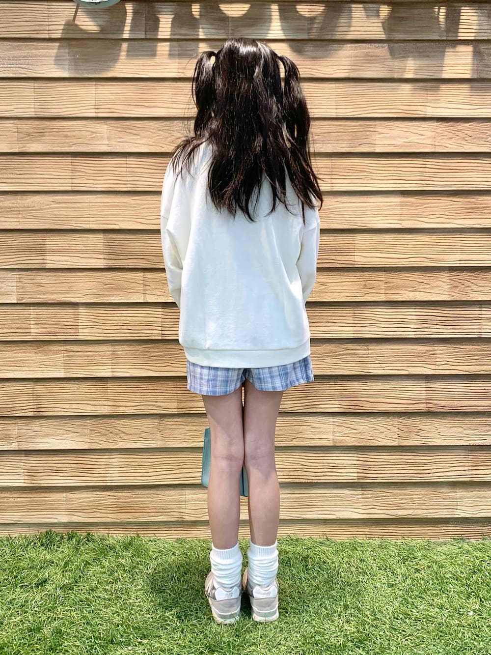 ホワイト系のスウェット、ブルー系のスカート、グリーン系のショルダーバッグを着用したキッズの夏コーディネートの5枚目の写真