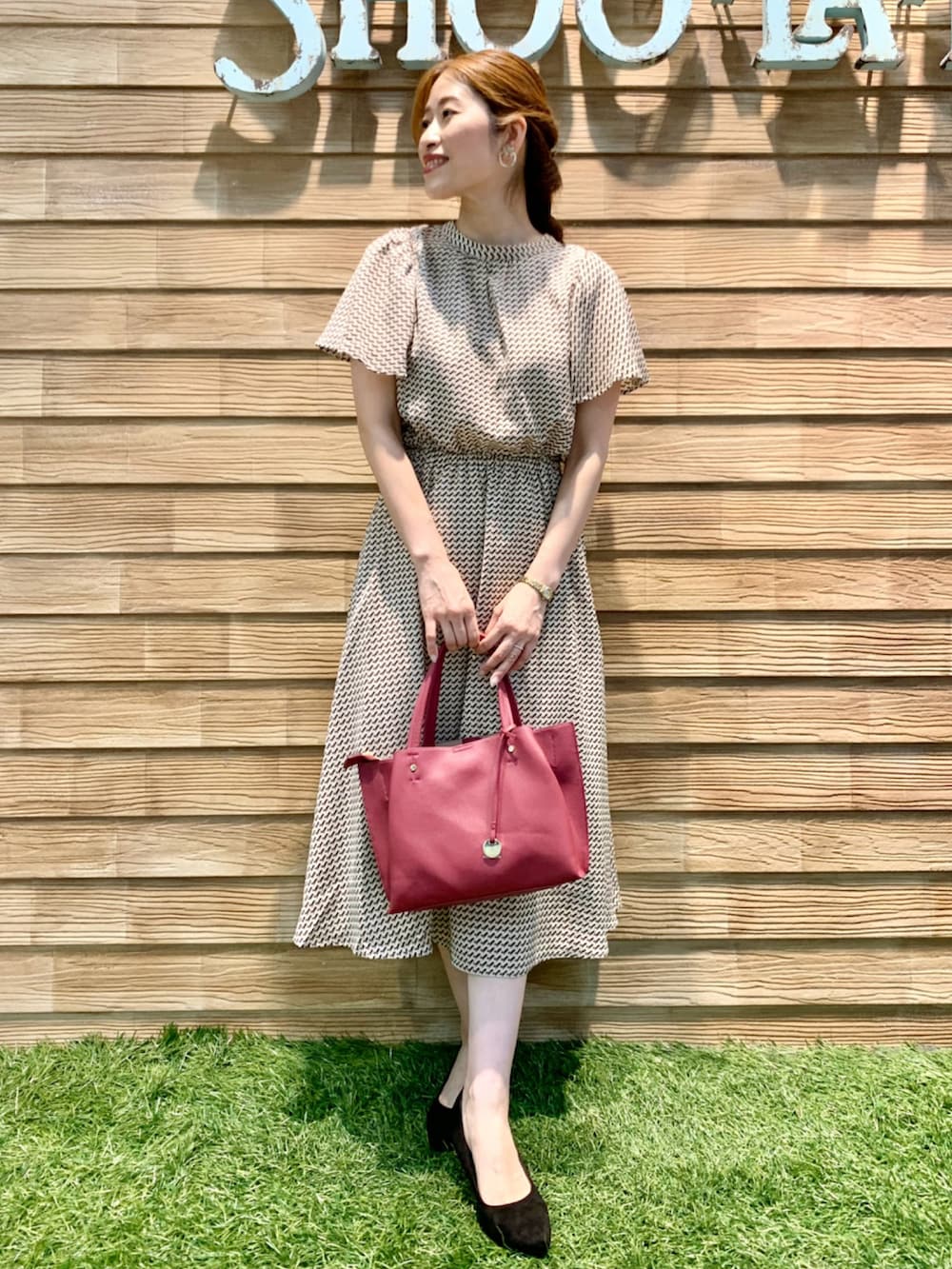 ベージュ系のワンピース、ピンク系のトートバッグ、ブラック系のパンプスを着用したレディースの秋コーディネートの3枚目の写真