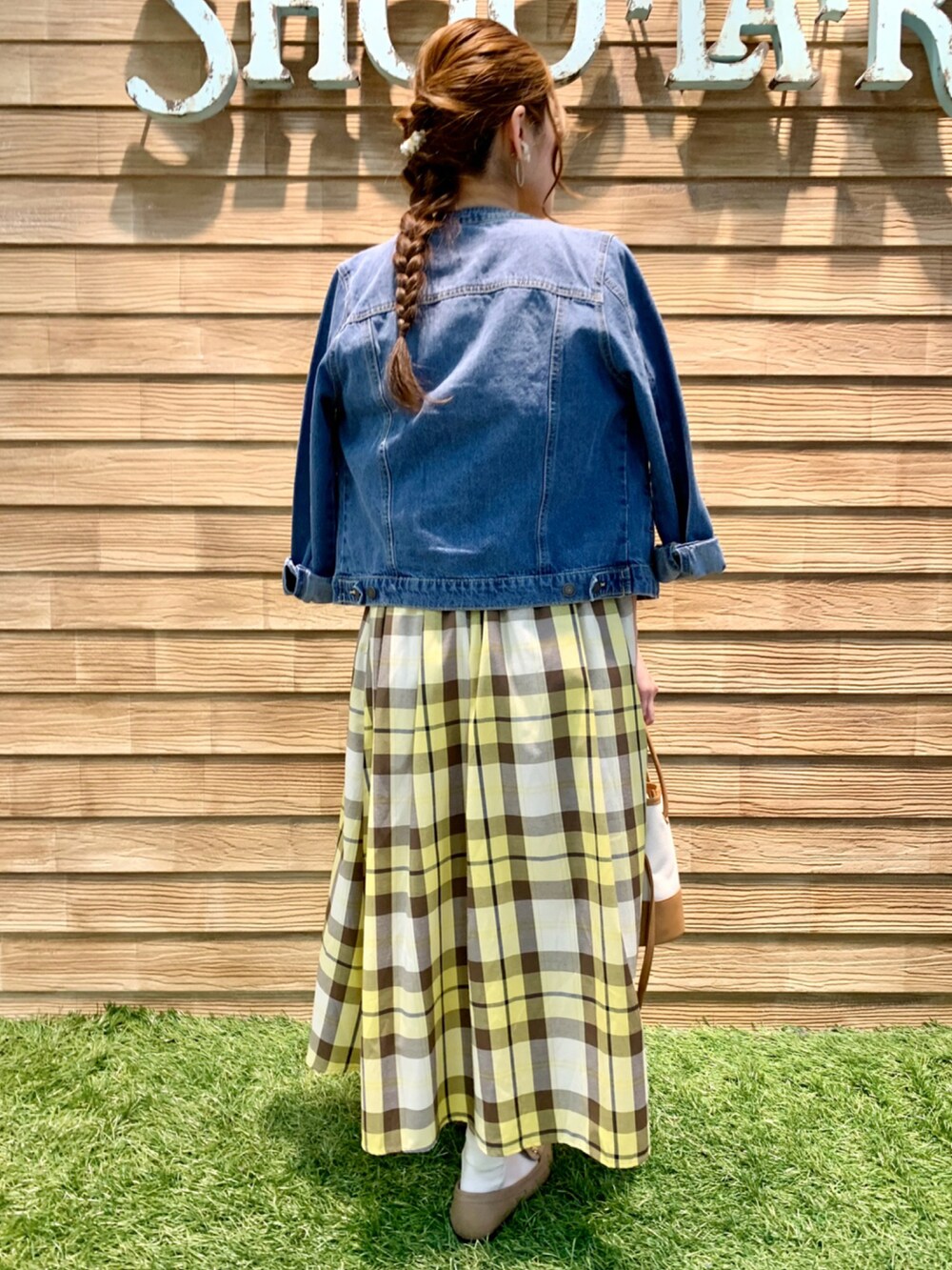 ブルー系のデニムジャケット、ホワイト系のニット/セーター、イエロー系のスカートを着用したレディースの春コーディネートの4枚目の写真