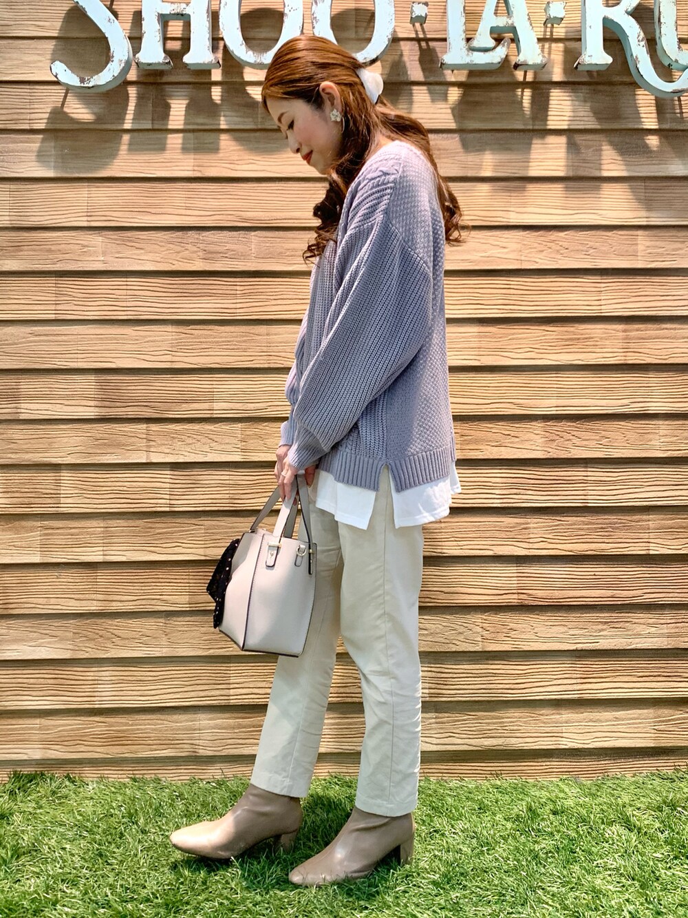 パープル系のニット/セーター、ホワイト系のその他パンツ、グレー系のトートバッグを着用したレディースの冬コーディネートの4枚目の写真