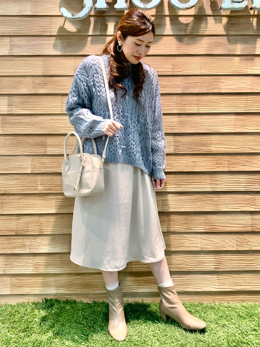 ブルー系のニット/セーター、ベージュ系のワンピース、ホワイト系のショルダーバッグを着用したレディースの冬コーディネートの2枚目の写真