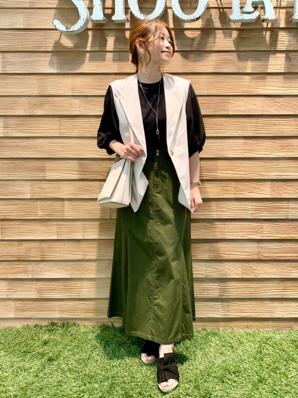 ベージュ系のベスト、ブラック系のTシャツ/カットソー、グリーン系のスカートを着用したレディースの夏コーディネートの3枚目の写真