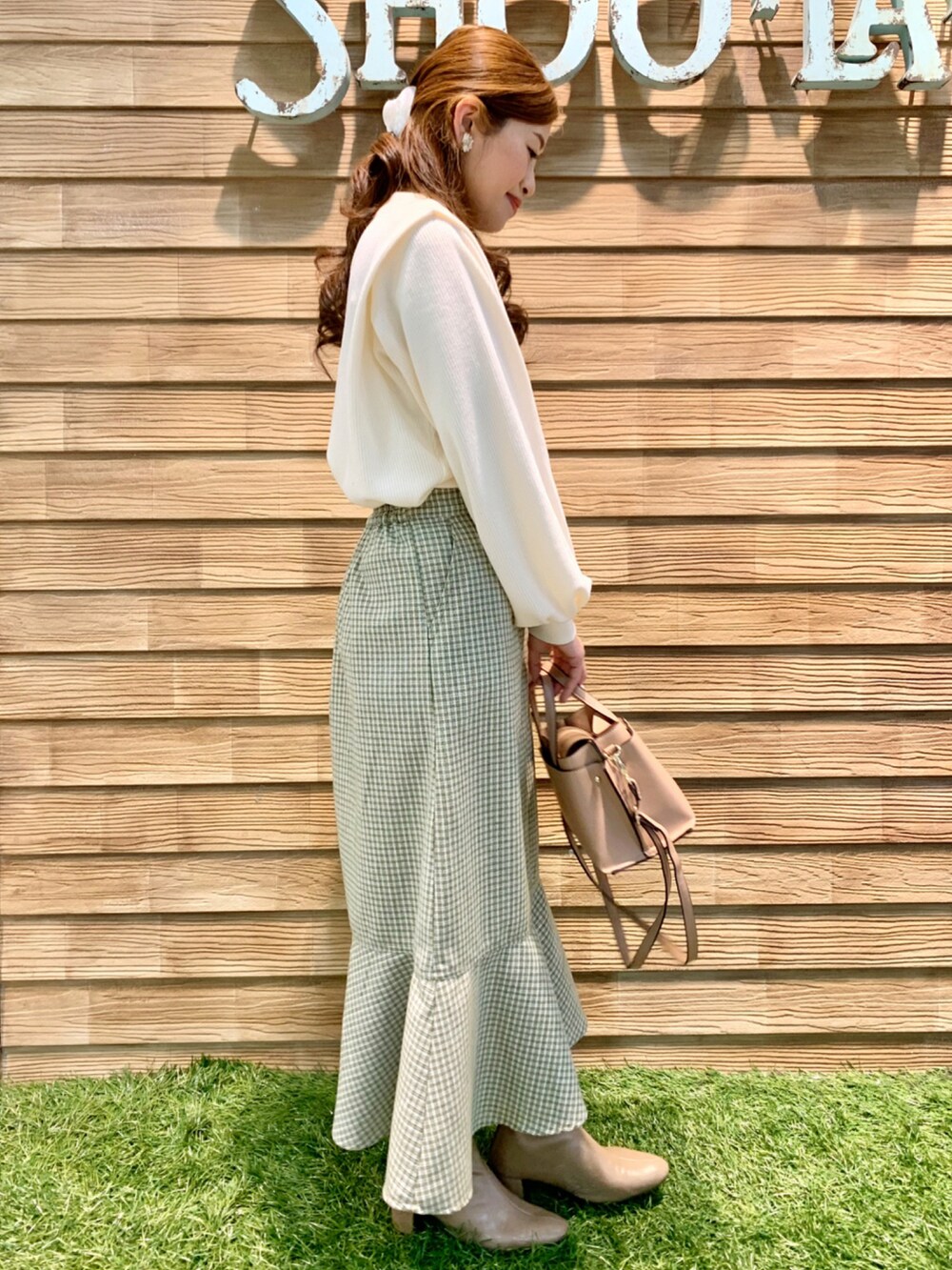 ホワイト系のTシャツ/カットソー、グリーン系のスカート、ピンク系のショルダーバッグを着用したレディースの冬コーディネートの4枚目の写真