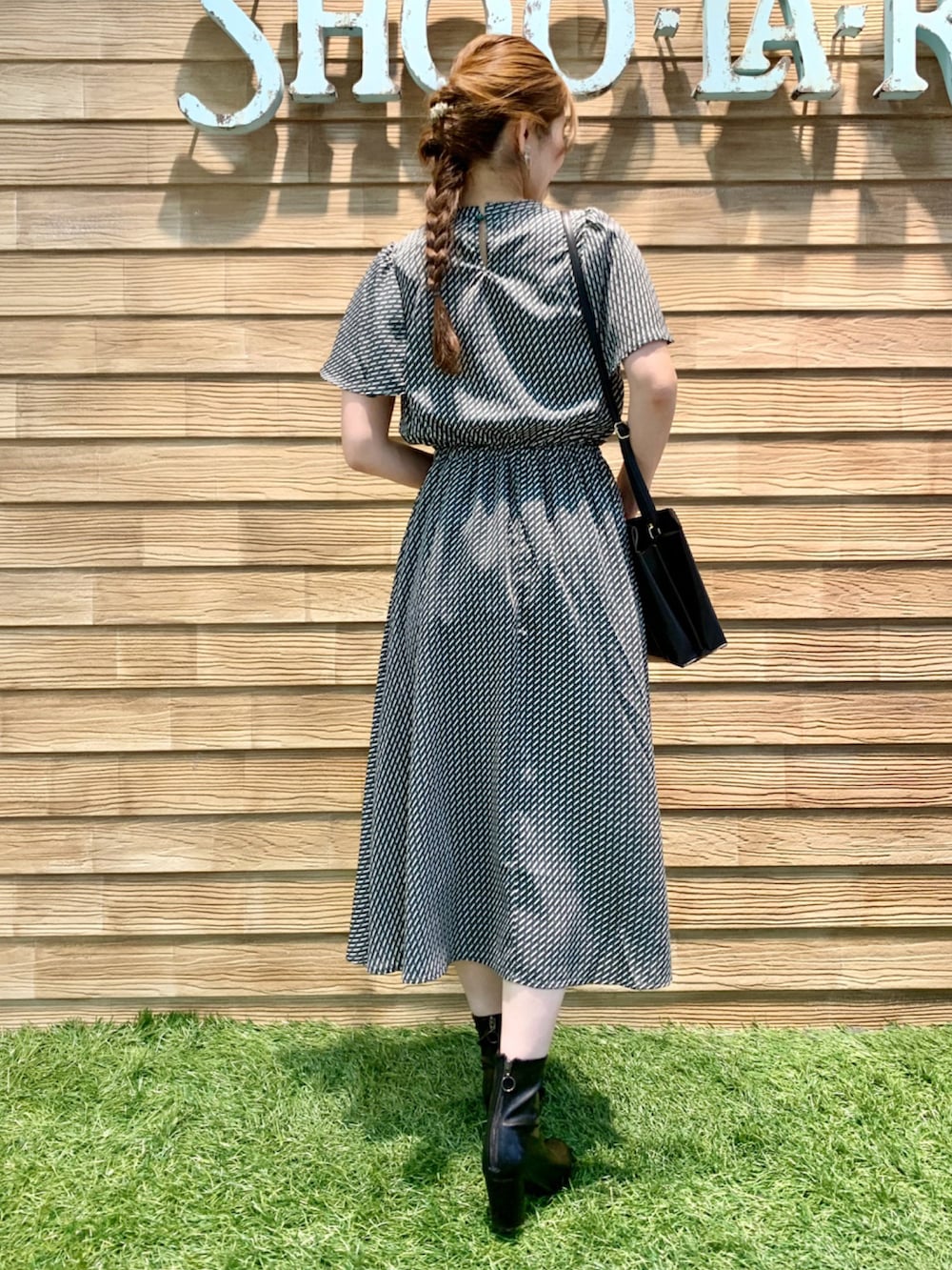 ブラック系のワンピース、ブラック系のショルダーバッグ、ブラック系のブーツを着用したレディースの秋コーディネートの5枚目の写真