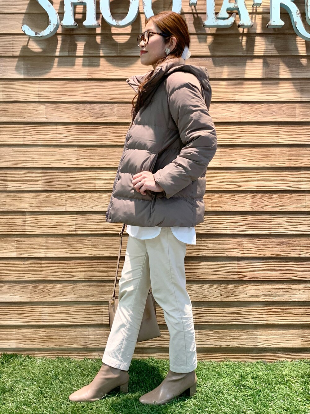 ベージュ系のダウンジャケット/コート、グリーン系のニット/セーター、ホワイト系のその他パンツを着用したレディースの冬コーディネートの2枚目の写真