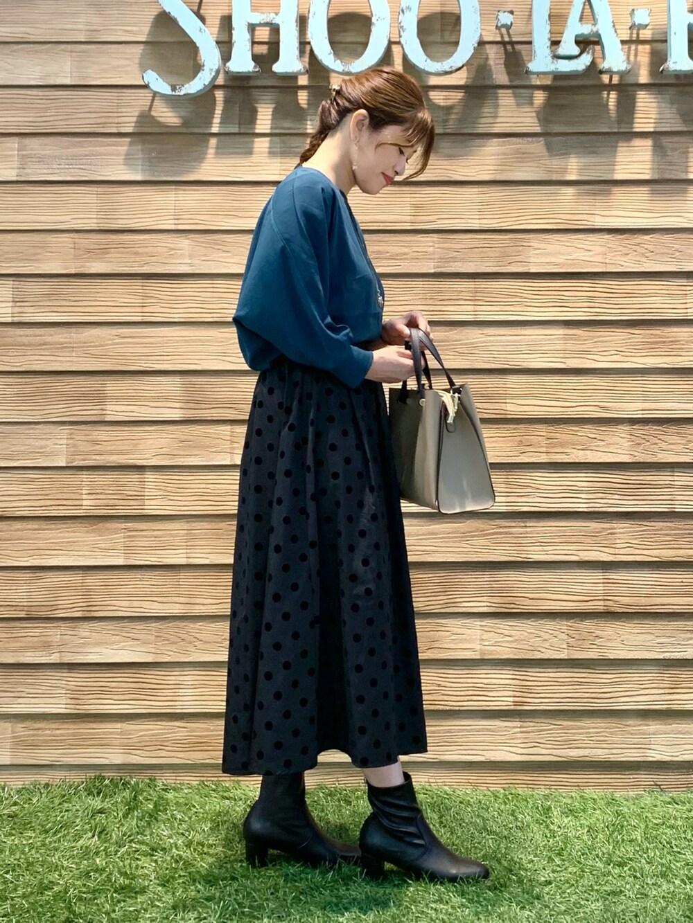 ブルー系のシャツ/ブラウス、グレー系のスカート、ベージュ系のトートバッグを着用したレディースの冬コーディネートの4枚目の写真